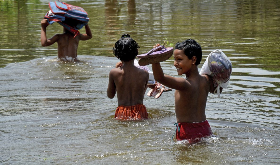 Barn på väg till skolan i ett översvämmat distrikt i Bangladesh 2017.