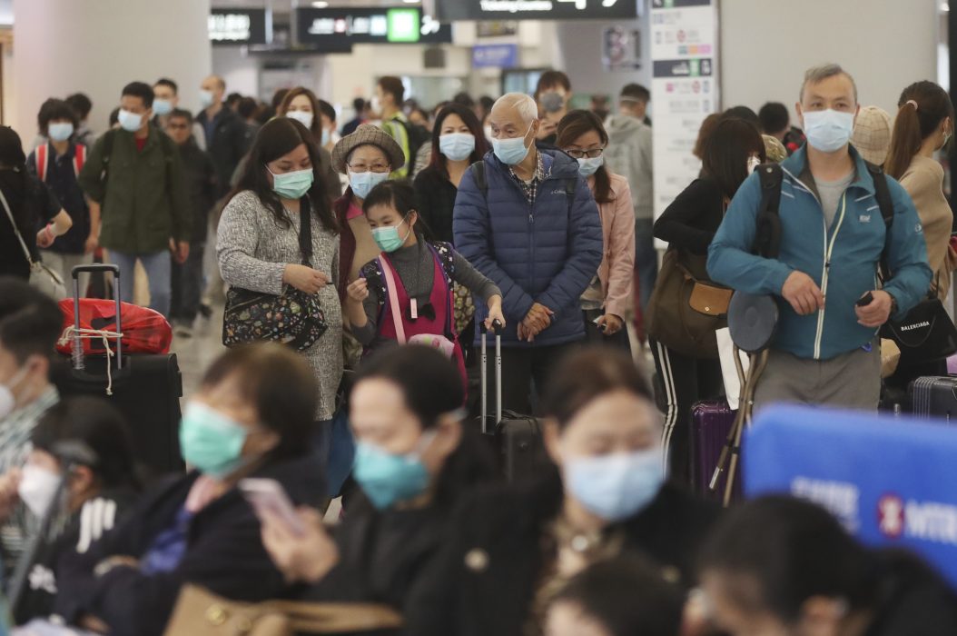 Tågpassagerare med ansiktsmask på en station i Hongkong.
