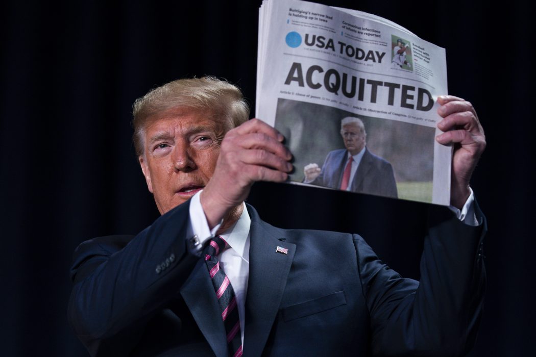 USA:s president håller upp en tidning med rubriken: "Frikänd".