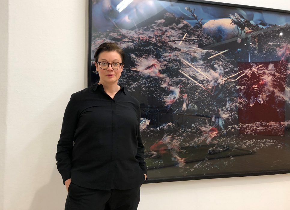 Anna Johansson, curator på Malmö konstmuseum framför ett fotografi av Cindy Sherman.