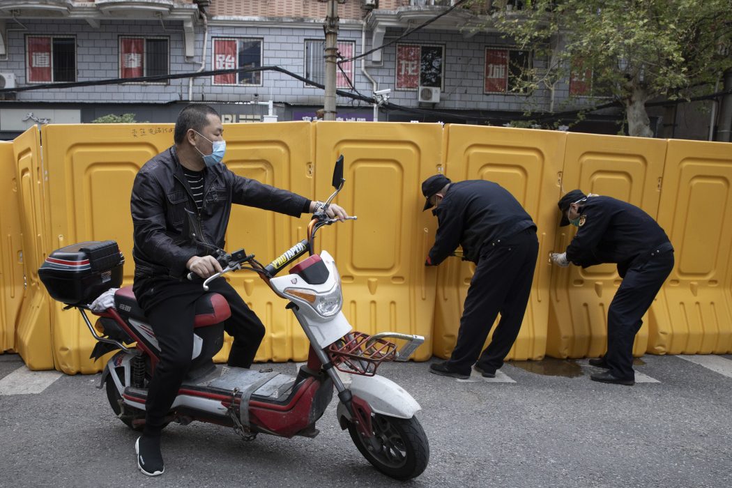 Plastbarriärer, som sattes upp för att skilja av bostadsområden från varandra under virusutbrottet, rivs i den centralkinesiska staden Wuhan.