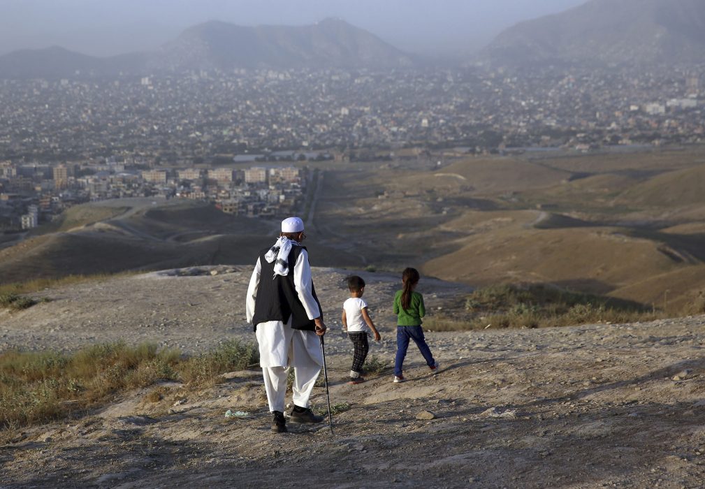 En äldre man i utkanten av Kabul i Afghanistan tillsammans med sina två barnbarn.