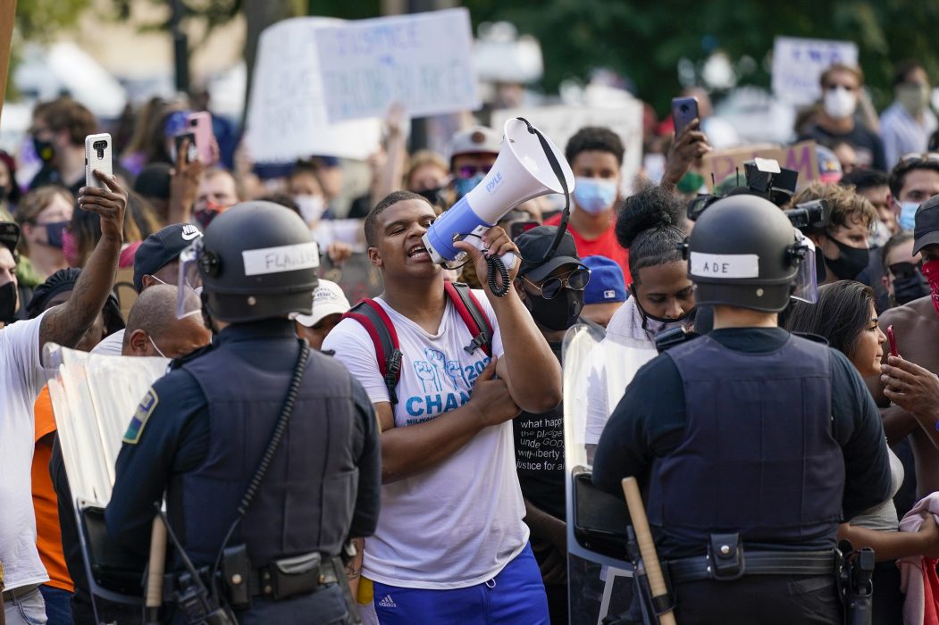 Demonstranter i Kenosha, Wisconsin, protesterar mot att polisen i söndags sköt en svart man framför hans barn.