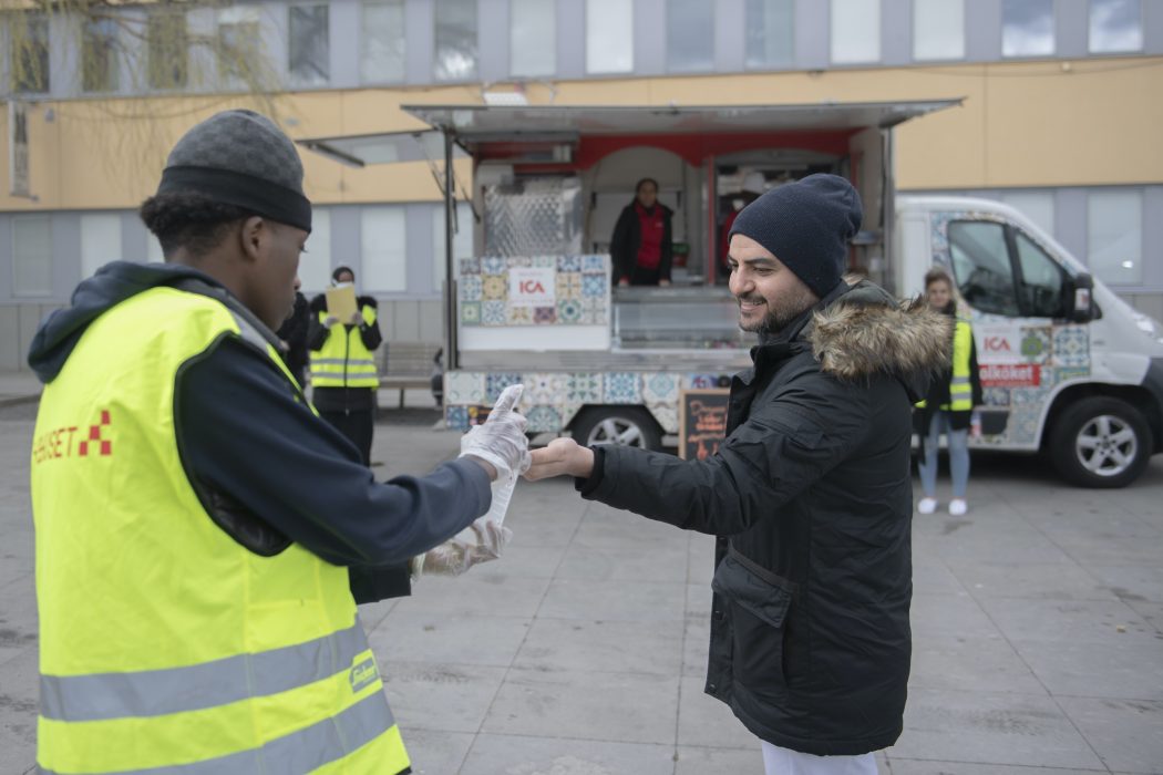 Ungdomsvolontärer i samarbete med Fryshuset delar ut gratis mat och informerar om coronaviruset och Covid-19 på olika språk i Tensta centrum.