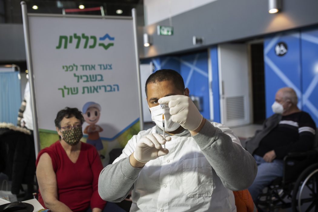 Vaccinationsdoser ges på löpande band på en vaccinationsplats utanför Jerusalem.