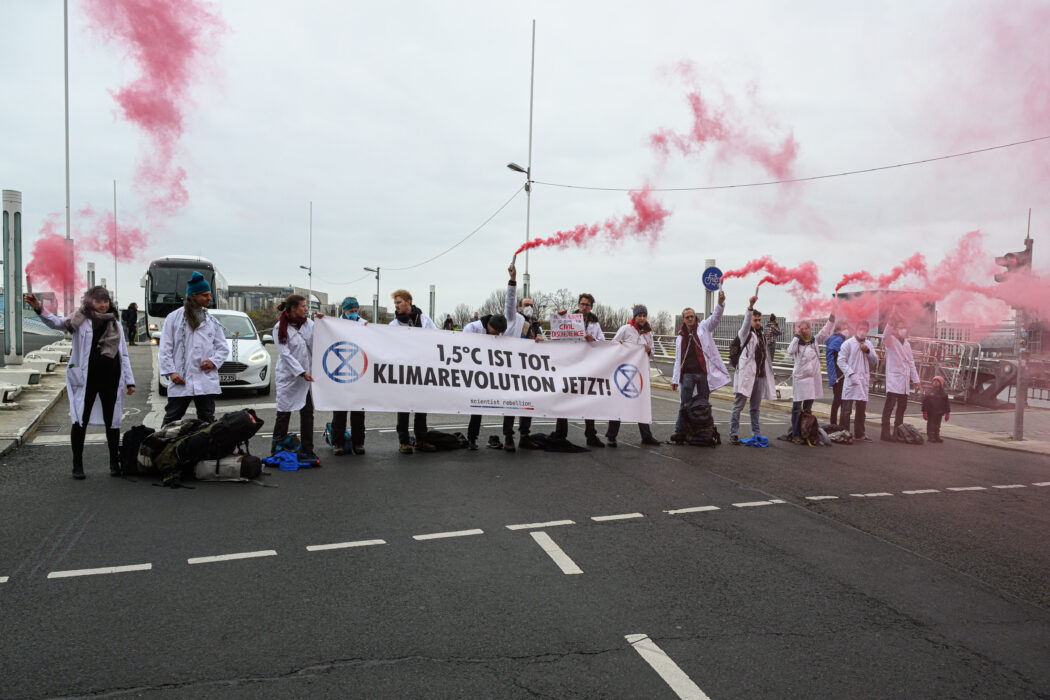 Under fyra timmar blockerade forskare en bro i Berlin innan de till slut fördes bort av polis.