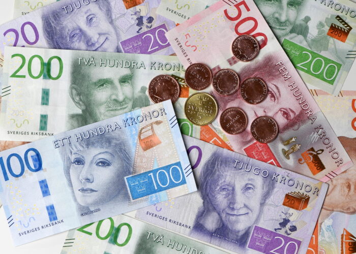 Svenska sedlar och mynt utspridda på en plan yta.
