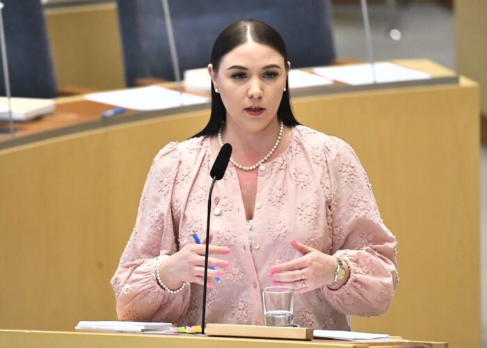 Ung kvinna talar i riksdagen. Yasmine Bladelius