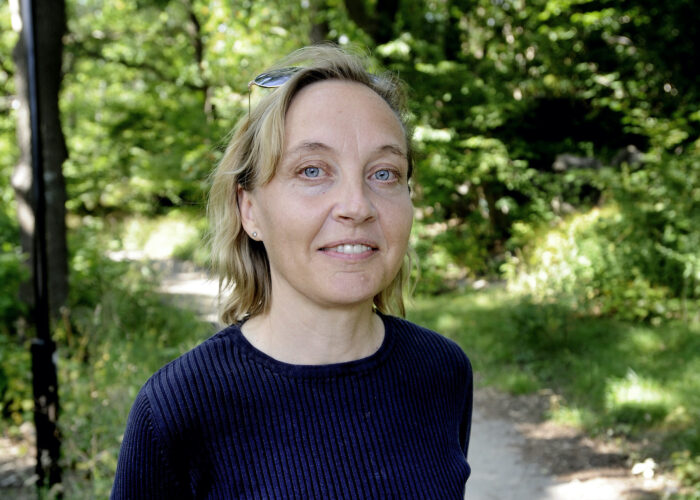 Porträtt av Lisa Gålmark, i bakgrunden en lövskog.