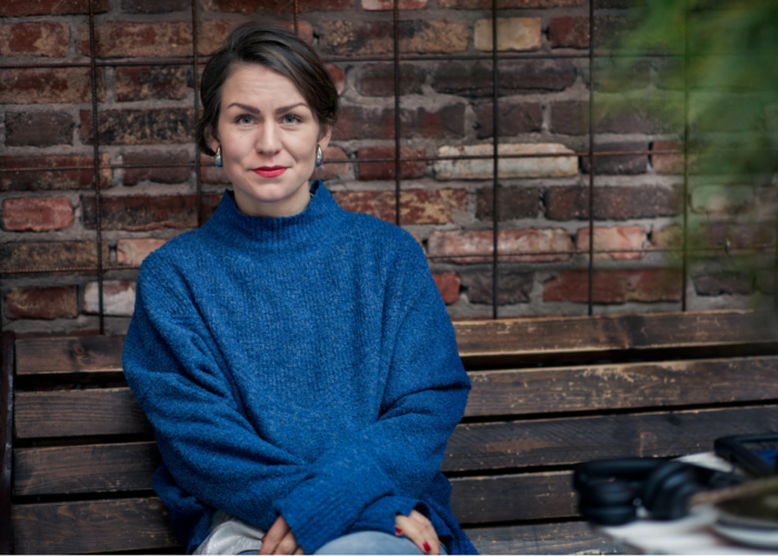 Li Kristjansdottir från Svenska matbanksnätverket i blå tröja framför tegelvägg.