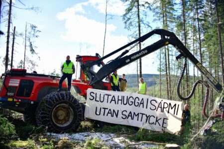 Aktivister på en skogsmaskin.